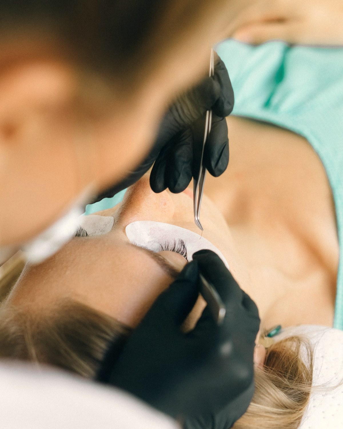 Lash artist applying extensions with tweezers